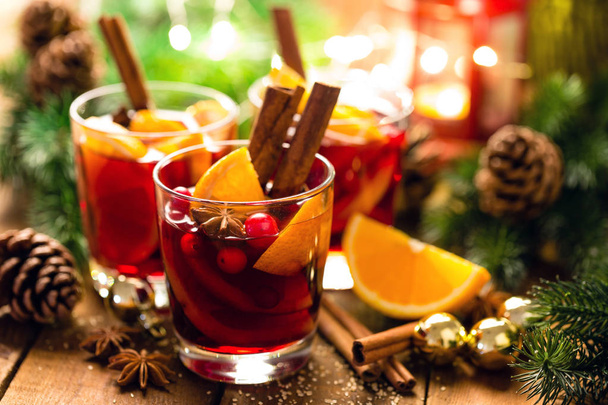 Christmas mulled red wine with spices and oranges on a wooden rustic table. Traditional hot drink at Christmas - Foto, Imagem