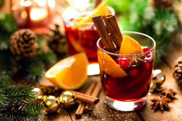 Christmas mulled red wine with spices and oranges on a wooden rustic table. Traditional hot drink at Christmas - Valokuva, kuva