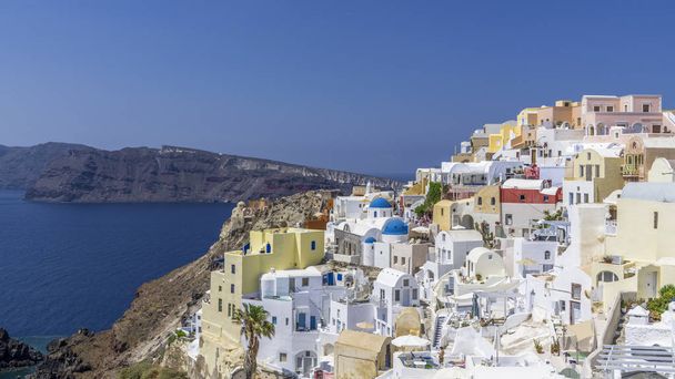 Colorful Greek houses on the steep banks of Santorini island in Oia. - Foto, imagen