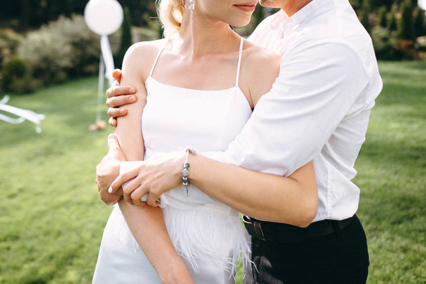 Cropped view of wedding couple posing hugging outdoor - 写真・画像