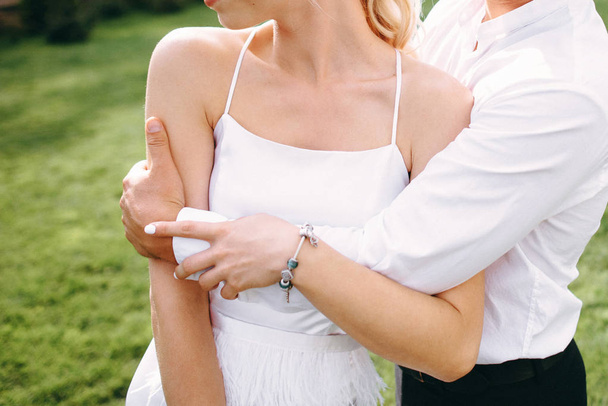 Vista ritagliata di coppia di nozze posa abbracci all'aperto
 - Foto, immagini