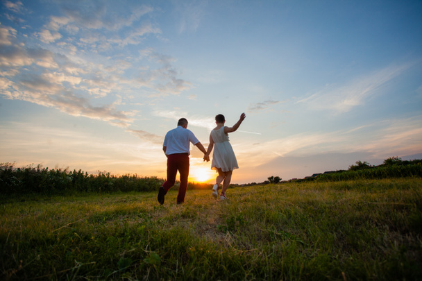 Rustic wedding couple at sunset in the summer outdoors - Фото, изображение