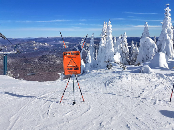 Señal de precaución y advertencia en una estación de esquí sobre rocas y obstáculos sin marcar en el comienzo de un sendero
. - Foto, imagen
