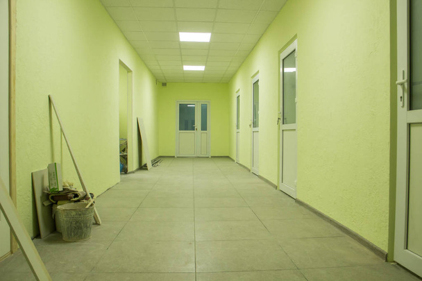 Le couloir de l'hôpital dans lequel est en cours de rénovation dans des tons légèrement verts
 - Photo, image