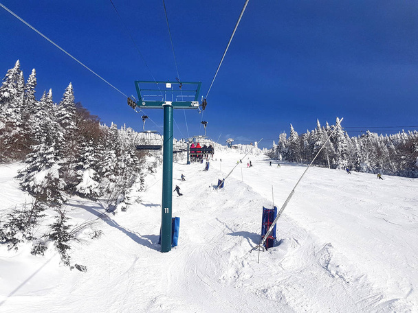 Telesillas y senderos en la estación de esquí en un día soleado y hermoso
. - Foto, Imagen