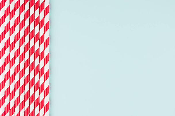 Funny festive bright abstract background - striped red cocktail straws on pastel candy mint color backdrop. - Foto, Imagem