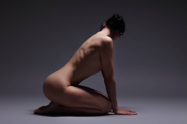 mladý sportovní nahá dívka na tmavém pozadí - Fotografie, Obrázek