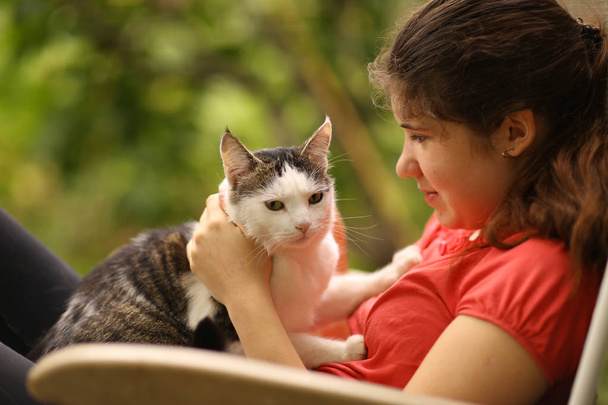 zomer zonnige foto van tiener meisje grooming kat met borstel close-up foto - Foto, afbeelding