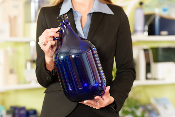 Empresaria sosteniendo botella azul
 - Foto, Imagen