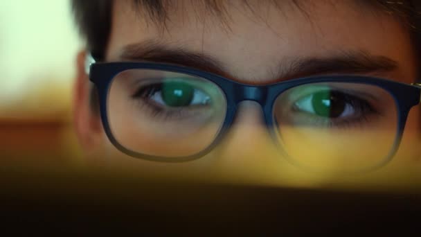 Ένα νεαρό αγόρι που φοράει γυαλιά ρολόγια οθόνη υπολογιστή - Πλάνα, βίντεο