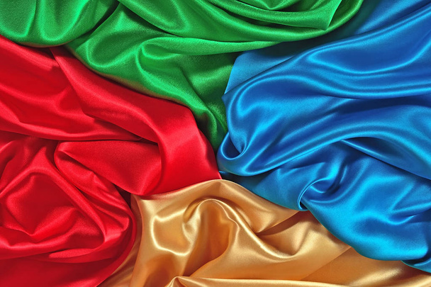 Естественная синяя, красная, золотая и зеленая атласная ткань в качестве фоновой текстуры
 - Фото, изображение