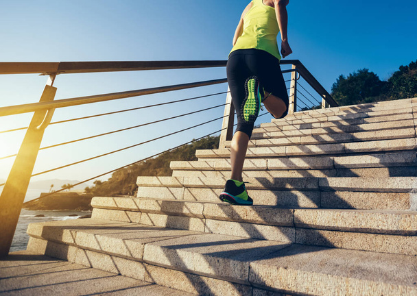 Pojęcie zdrowego stylu życia. Sportowe kobieta działa w górę nad morzem i kamiennymi schodami  - Zdjęcie, obraz
