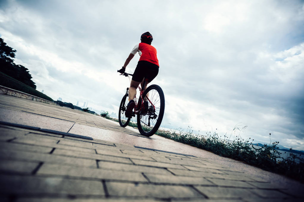 Femme cycliste équitation VTT sur le bord de mer
 - Photo, image