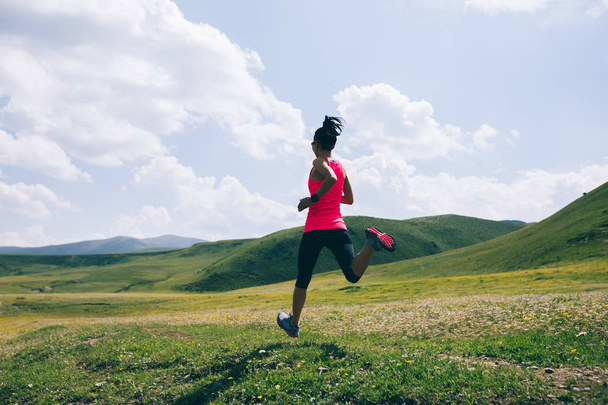 Young fitness woman trail runner running grassland   - Фото, зображення