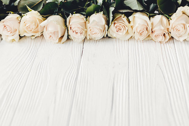 木製の背景にバラを白、テキストの領域をコピーします。花のグリーティング カード。結婚式招待状または幸せな母の日の概念。白い花のスタイリッシュなボーダー。こんにちは春 - 写真・画像