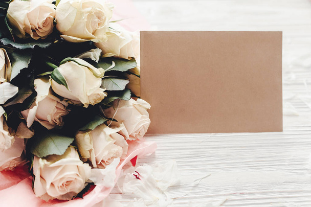 Bílé růže s prázdnou kartou na dřevěné pozadí, prostor pro text. Květinový pozdrav card maketa. Svatební pozvánka, šťastné matky den koncept. Valentýn - Fotografie, Obrázek