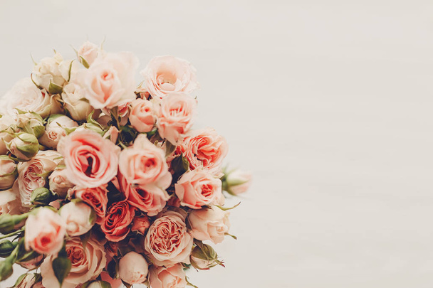 Roze roosjes boeket op witte achtergrond geïsoleerd. Bovenaanzicht met ruimte voor tekst. Floral wenskaart mockup. Bruiloft uitnodiging, gelukkige moeder en dag van de Valentijnskaart. Vintage Toon - Foto, afbeelding