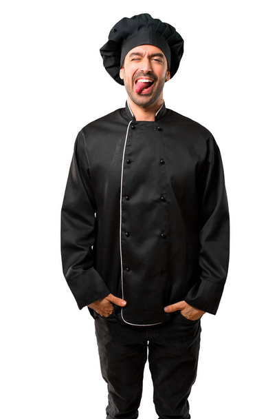 Kuchař muž v černé jednotné zobrazení jazyka na kameru s legrační pohled na izolované bílé pozadí - Fotografie, Obrázek