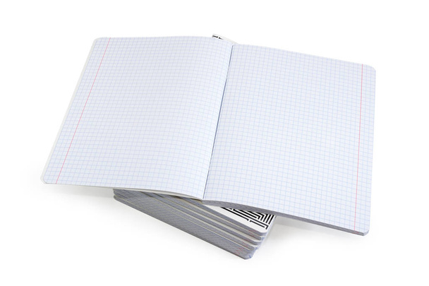 Άνοιγμα κενό βιβλίο ασκήσεων με σελίδες τετράγωνο χαρτί και κόκκινες κάθετες γραμμές για ένα περιθώρια σε μια στοίβα από άλλα ίδια βιβλία ασκήσεων σε λευκό φόντο - Φωτογραφία, εικόνα