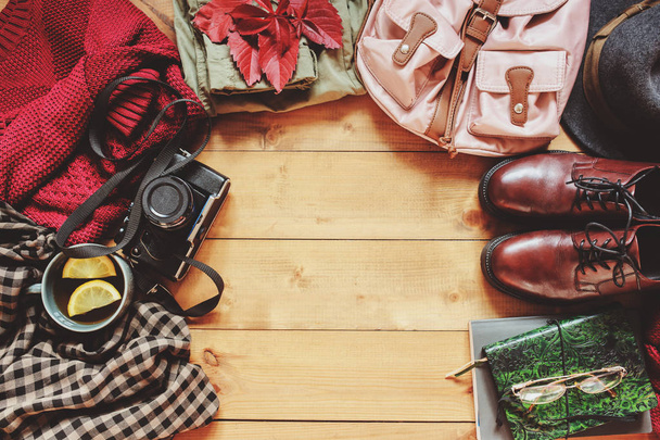 autumn women fashion clothes set with cozy sweater, shoes, plaid shirt, vintage photo camera, backpack and cup of tea. Fall seasonal walk concept, flat lay with empty space  - Φωτογραφία, εικόνα