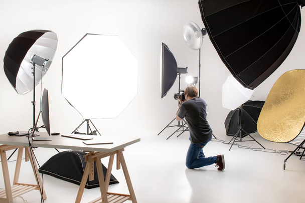 Photographe travaillant dans un studio d'éclairage moderne avec de nombreux types de flash et d'accessoires. prendre à la zone vide dans ressembler à une balle pour quelqu'un. Idée pour ajouter des personnes ou des objets à la photo
. - Photo, image
