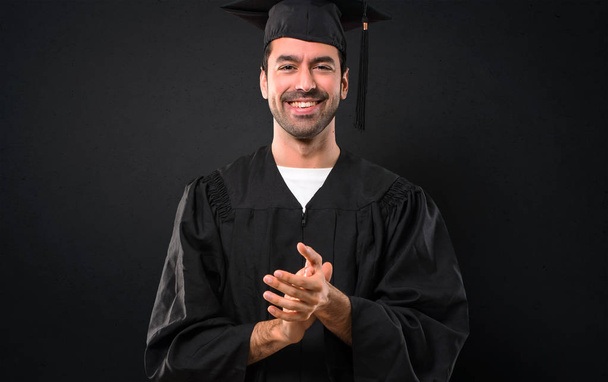 Muž na jeho maturitní den univerzity tleskají po prezentaci na konferenci na černém pozadí - Fotografie, Obrázek