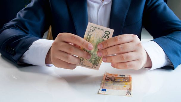 Closeup photo of businessman choosing using and investing in US dollars instead of Euro - Photo, image