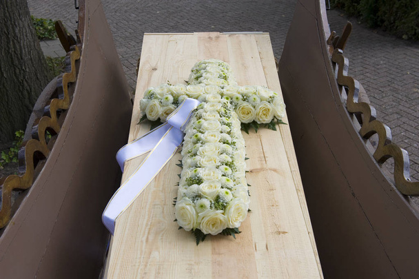 A cross made of flowers on a coffin on a charlot - Photo, Image