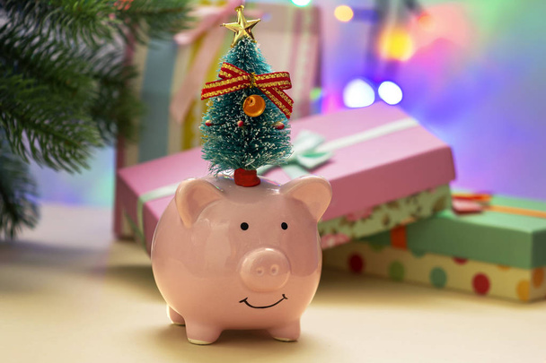 Piggy bank met kleine kerstboom op hoofd - Foto, afbeelding