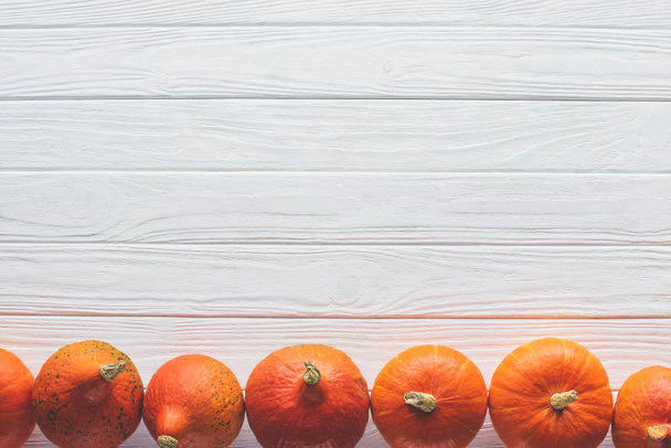 top view of row of orange ripe pumpkins on table side - Foto, Imagem