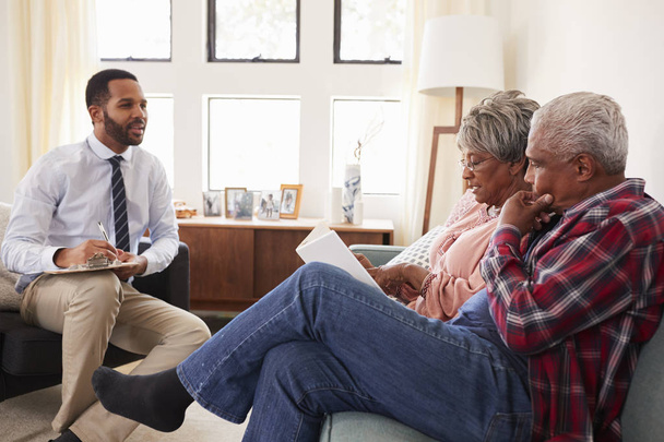 Senior Couple Meeting With Male Financial Advisor At Home - Photo, Image