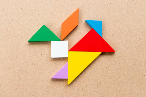 Puzzle couleur tangram en forme de lapin sur fond bois
 - Photo, image
