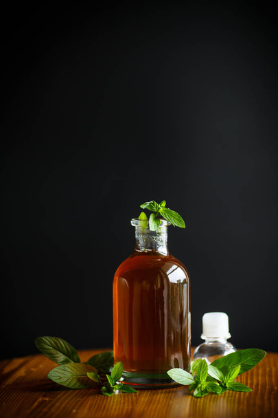 Mint syrup in a glass bottle isolated on a black background - Zdjęcie, obraz