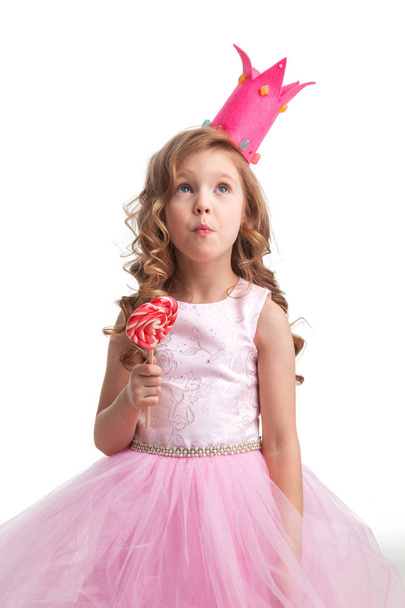 Beautiful little candy princess girl in crown holding big pink heart shaped lollipop - Photo, Image
