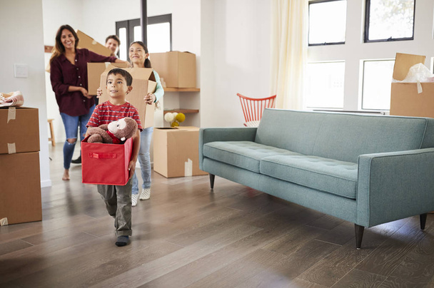 Excited Family Carrying Boxes Into New Home On Moving Day - Photo, image