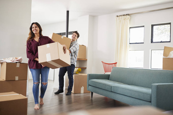 Excited Couple Carrying Boxes Into New Home On Moving Day - Foto, imagen