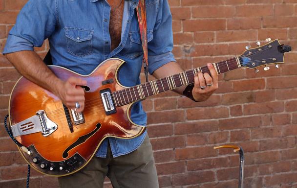 musicista di strada suona con la chitarra un pezzo rock a beneficio del suo pubblico
 - Foto, immagini