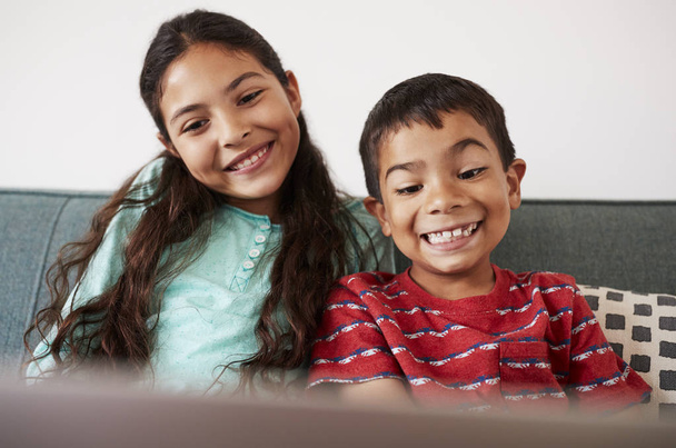 Brother And Sister Sitting On Sofa And Playing On Laptop Together - Foto, Imagem