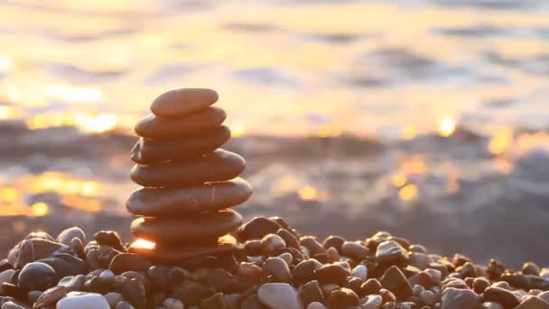 Pyramid of pebbles at sunrise on the sea. - Footage, Video