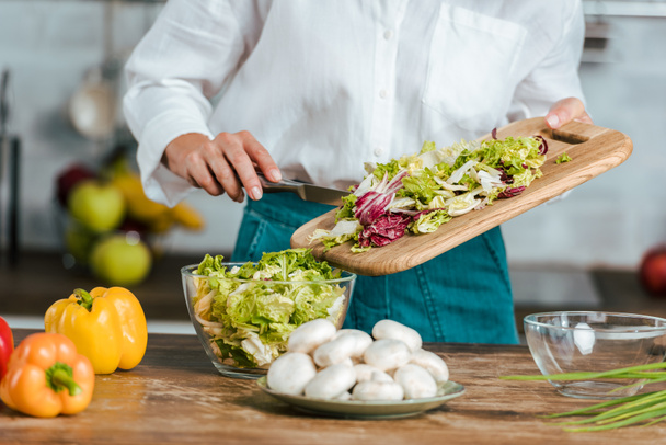 cropped shot of woman making healthy salad at kitchen - Foto, afbeelding