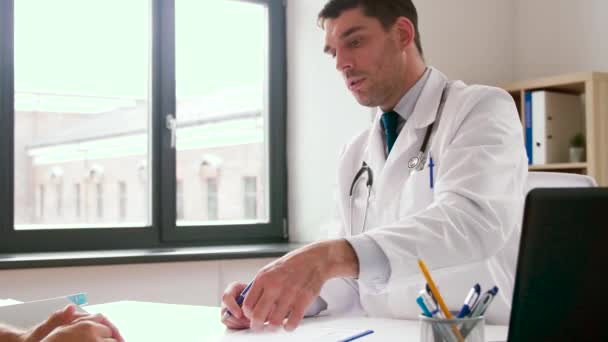 doctor giving prescription for patient at clinic - Felvétel, videó