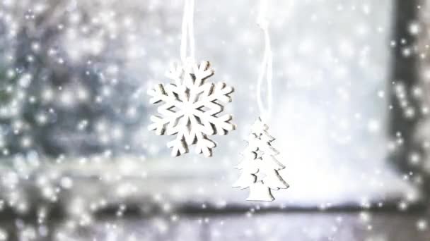 2 つの小さな白いクリスマスの木のおもちゃの灰色の壁の背景に掛かっています。 - 映像、動画