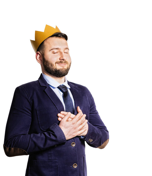 The concept of leadership, excellence. Portrait of a smiling man with a golden crown on his head. Isolated on white background. - Foto, afbeelding