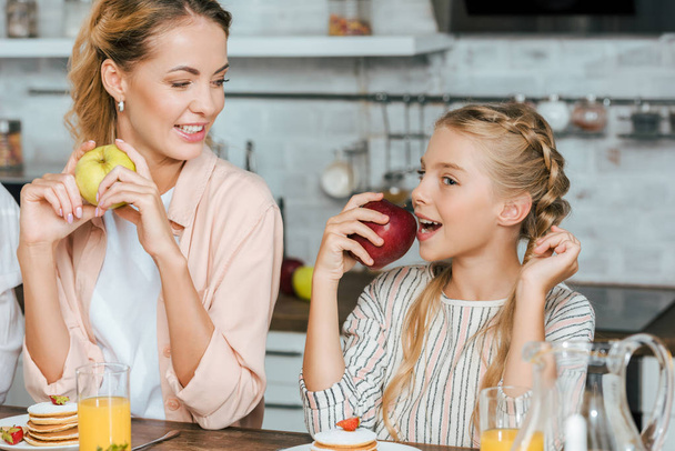 мать и дочь едят блинчики и яблоки дома
 - Фото, изображение