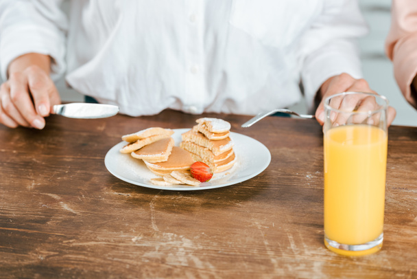 cropped shot of woman eating pancakes with strawberry - Fotografie, Obrázek