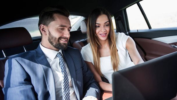 Business man and woman working together in the car - Foto, Imagen