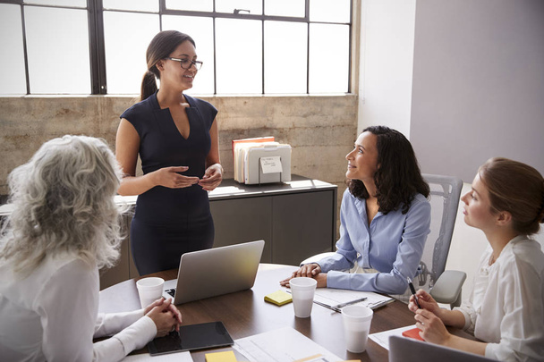 Female manager in glasses addressing businesswomen in meeting - Foto, immagini