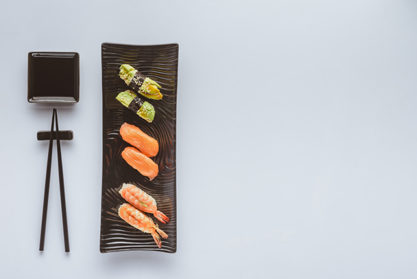 top view of delicious sushi set and chopsticks isolated on white - Φωτογραφία, εικόνα