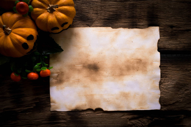 Horní pohled starého papíru s ghost žlutá dýně na dřevěné desce. koncept Halloween. - Fotografie, Obrázek