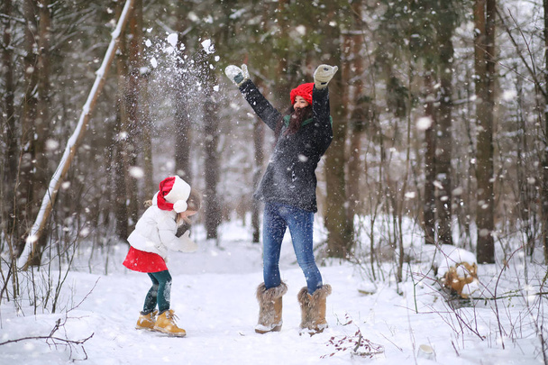 ein Wintermärchen, eine junge Mutter und ihre Tochter fahren Schlitten - Foto, Bild